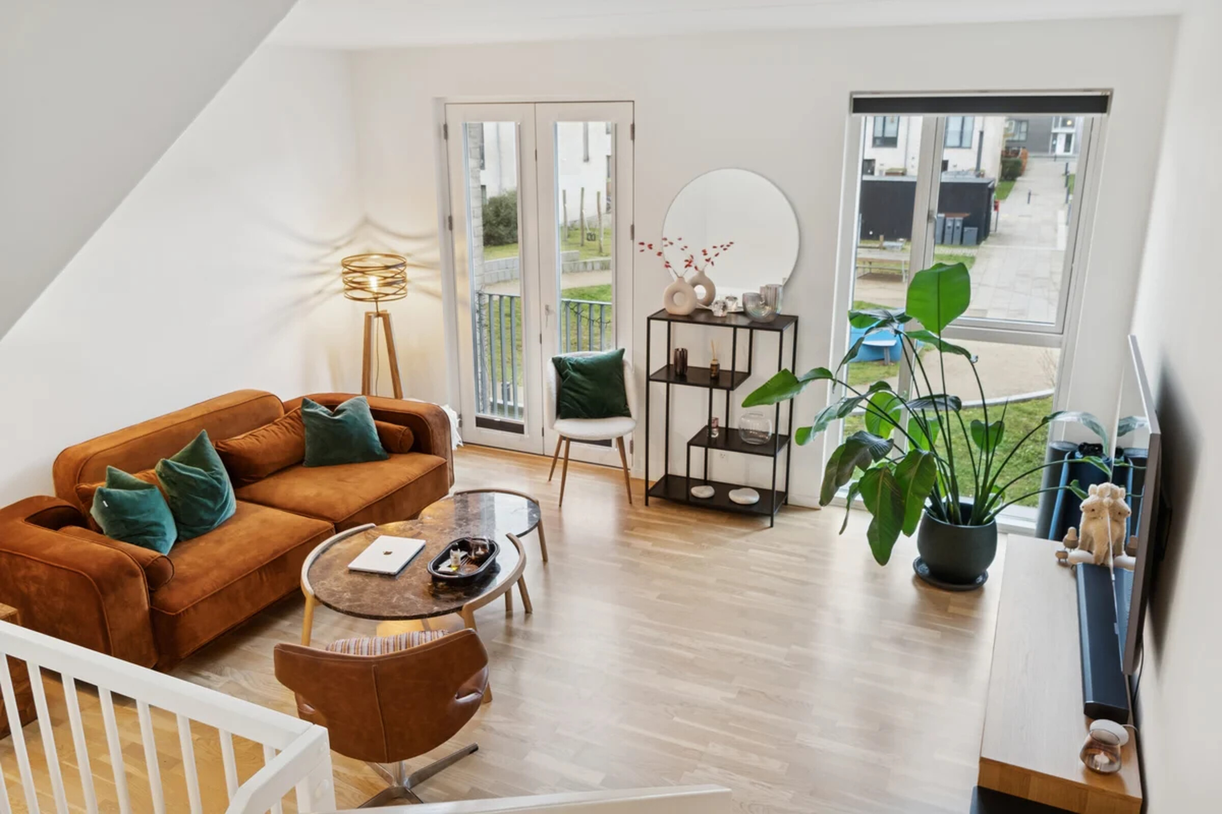 Stue med cognacfarvet sofa og naturligt lys